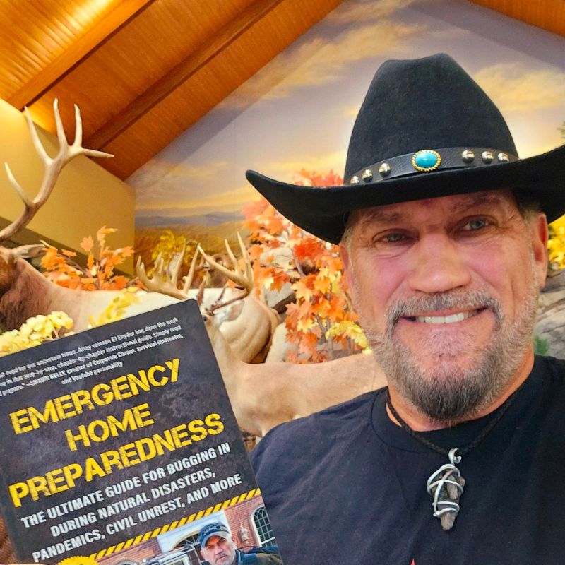 EJ Snyder holding an 'Emergency Home Preparedness' book with a scenic background